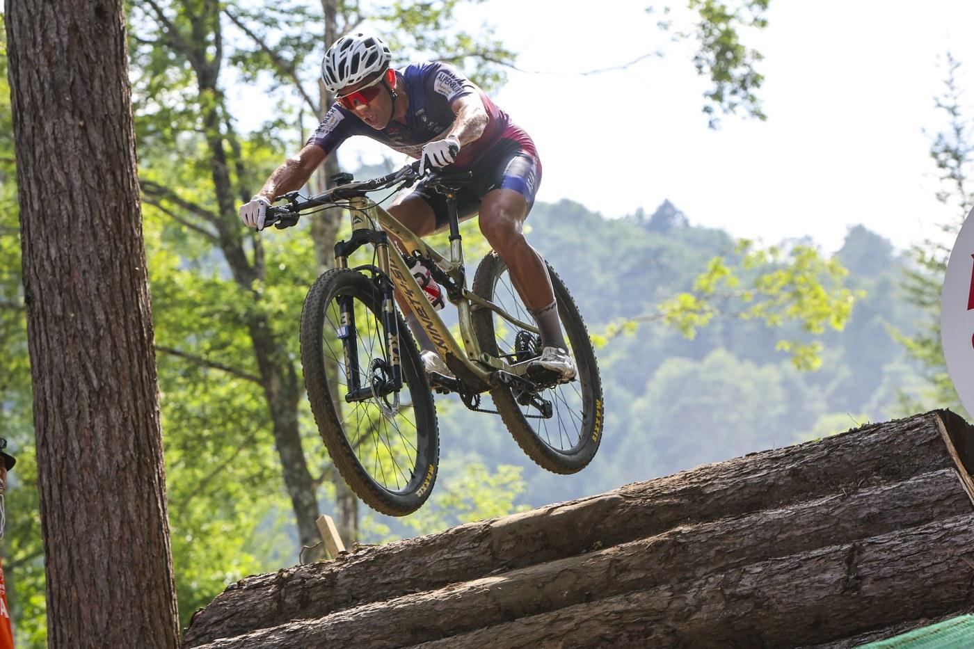 Kohei Yamamoto riding over a woodland trail feature.